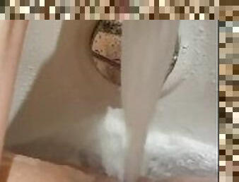 Horny babe makes clit swell in hotel bath