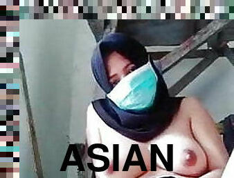Asian girl in a hijab rubs her pussy