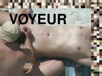 Voyeur 7925-Handjob at nudist rocky beach