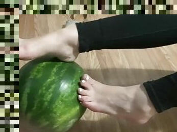 Sexy feet playing with a watermelon