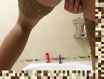 Juicy MILF in red lingerie and stockings masturbates in the bathroom
