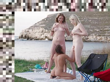 Petite girls make out in flawless threesome by the sea
